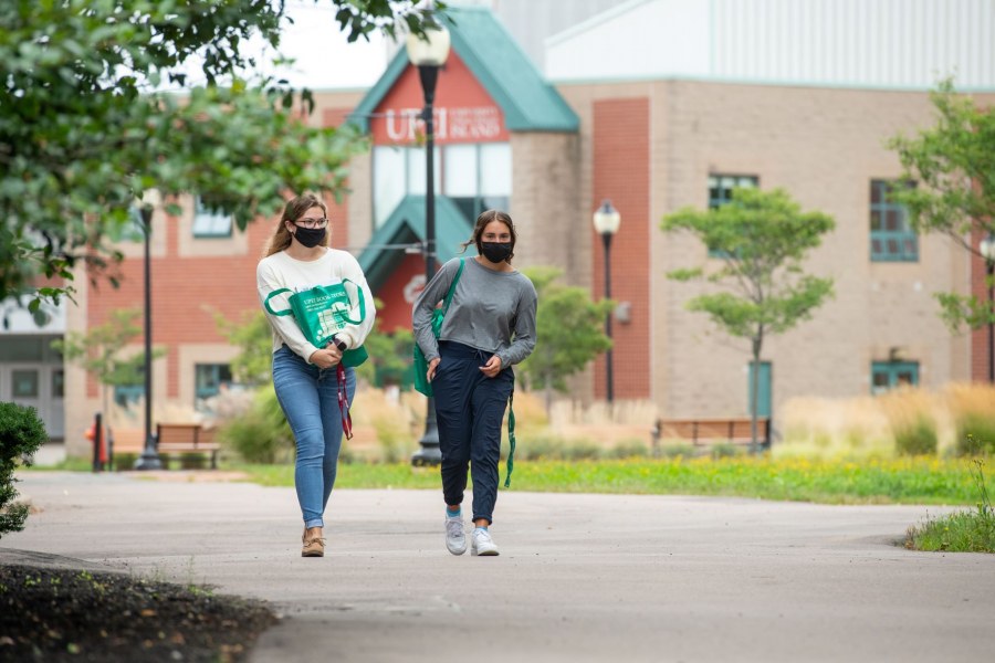 Students wearing masks stroll on the UPEI campus.