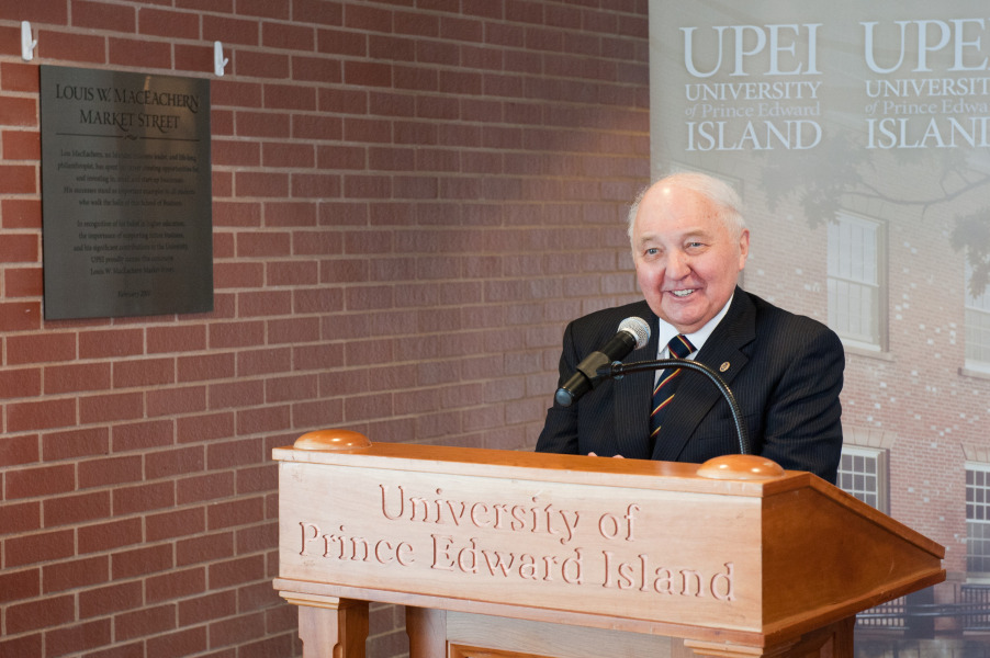 photo of man smiling and standing at a podium