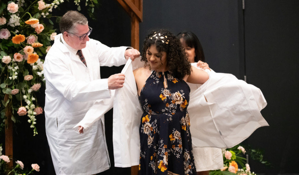 Dr. Alondra Crespo-Rivera (centre) receives her white coat from AVC’s Dr. Patrick Burns (left) and her mother, Sonylma Rivera (right). 