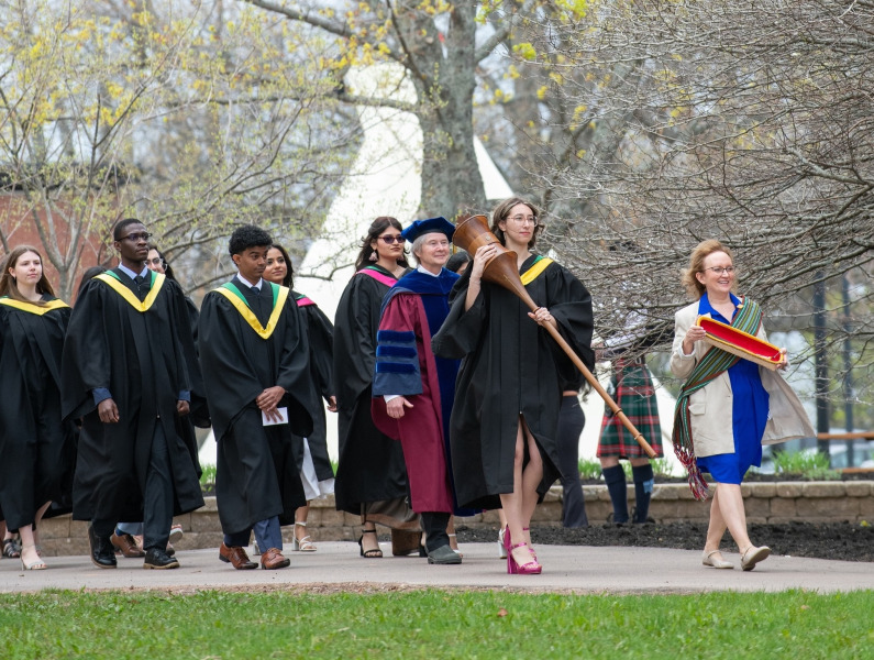 Marshal, Sue Dawson; Macebearer, Shanelle Berthier, Faculty of Science; and Eagle Feather Bearer, Erin Reid, assistant professor, Faculty of Indigenous Knowledge, Education, Research, and Applied Studies, lead graduates in the Faculty of Science into the Chi-Wan Young Sports Centre for their Convocation ceremony on May 16. 