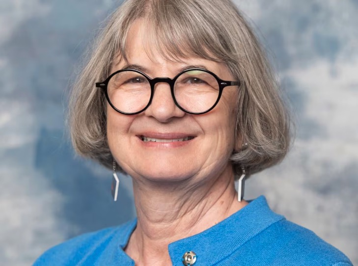 Portrait photo of woman wearing glasses and blue jacket